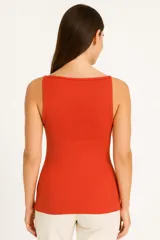 Musculosa naranja de punto canalé, con breteles finos y escote recto.