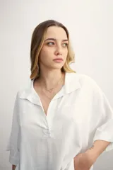 Blusa negra de lino con cuello polo y mangas cortas amplias.