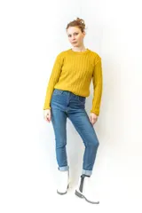 Sweater mostaza de punto acanalado con cuello redondo y mangas largas.