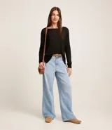 Suéter negro de punto con cuello redondo y mangas largas.