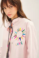Camisa rosa claro de algodón con cuello mao, bordado a mano con detalle en el cuello, cierre frontal con botones de nácar y mangas largas.