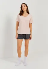 Pijama compuesto por remera manga corta con cuello en V color rosa pálido y short gris jaspeado. Incluye medias blancas.