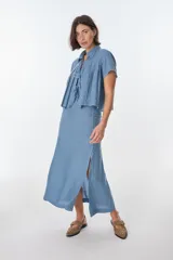 Falda larga de lino color celeste, de corte recto y con tajo lateral.