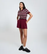 Short de sastrería color bordó, con pliegues delanteros, cierre interno y cinturón fino desmontable.