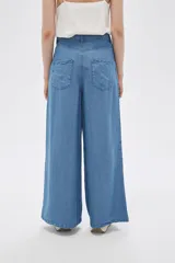 Pantalón de lyocell azul con bolsillos, corte holgado y de calce alto.