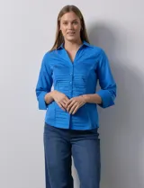 Camisa blanca de algodón marca Zac & Rachel, con cuello con solapa, abertura central con botones, delantera tableada y laterales elastizados.