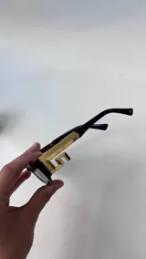 Lentes de sol negros de montura rectangular y gruesa, con cristales oscuros.