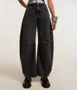 Pantalón de jean azul oscuro, corte barrel, con cintura con trabillas, cierre con botón y cremallera, bolsillos delanteros y traseros, y recortes en las rodillas y el bajo.