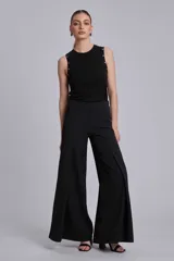 Musculosa negra ajustada al cuerpo con cuello redondo y detalles de tachas metálicas plateadas en los hombros y sisas.