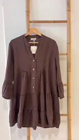 Vestido corto negro de lino, con escote en V, botones frontales y mangas largas acampanadas con volados.