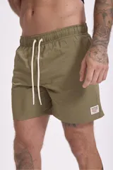 Short de baño color verde oliva con textura de rayas finas en relieve y cordón de ajuste blanco en la cintura.