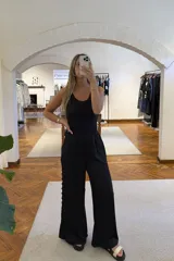 Blusa sin mangas color negro con textura brillante.