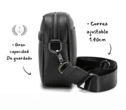 Bandolera negra de cuero sintético con correa ancha ajustable y desmontable. Cuenta con cierre superior, bolsillo frontal con tiracierre customizado, forro interno y cuatro bolsillos en total (dos exteriores y dos interiores).