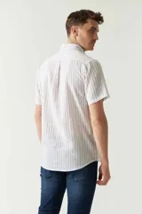 Camisa de manga corta confeccionada en lino y algodón a rayas verticales rojas y azules. Tiene un corte semi slim y logo bordado en el pecho.