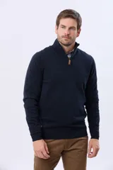Buzo tejido de algodón color azul marino, con cuello alto y cierre frontal parcial con detalle de cuero en el tirador.