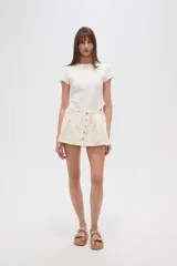 Minifalda plisada color crema con cintura elastizada y cierre frontal con botones de madera.