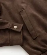 Campera marrón con cierre frontal, cuello inglés, bolsillos laterales y bajo con elástico. Presenta detalles de recortes en la parte superior. Marca Marfinno.