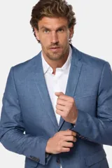 Saco azul de lino, corte clásico, con solapa de muesca, cierre de dos botones, bolsillo en el pecho y bolsillos laterales con solapa.