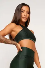 Top deportivo verde con textura tipo panal 3D, cuello alto y estructura firme.
