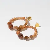 Aros tipo argolla con cuentas de piedra natural color marrón y detalles dorados.