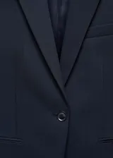 Blazer azul marino de corte entallado, con cuello de solapa de muesca, manga larga, hombros estructurados, dos bolsillos de ribete en la parte delantera, detalle de pinzas, abertura posterior y forro interior.