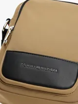 Cartera tipo bandolera Tommy Hilfiger color beige con detalles en negro y logo metálico de la marca en el frente.