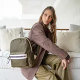 Mochila negra de nylon con bolsillo frontal con cierre y detalles en símil cuero. Tiene asa de mano, correas regulables y bolsillo trasero vertical con cierre. En el interior tiene dos bolsillos con cierre y uno abierto con división.