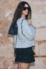 Minifalda negra con bordado floral y volantes escalonados.