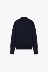 Jersey azul marino de punto liso, con cuello polo, manga larga, bolsillo de parche en el pecho y cierre frontal con botones.