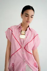 Vestido corto tipo camisa color beige con bordados florales en azul.