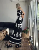 Vestido camisero largo negro con estampado de flores blancas y cinto incluido.