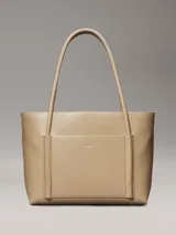 Cartera tote color beige de piel sintética estructurada y suave, con asas tubulares y bolsillo exterior con ranura en la parte delantera. Incluye un bolsillo interior extraíble.