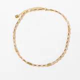 Gargantilla dorada con cuentas de piedra natural color durazno y detalles de acero dorado.