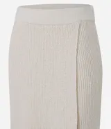 Pollera evasé midi de punto con cintura alta y elástico. Presenta un diseño con traspase delantero.