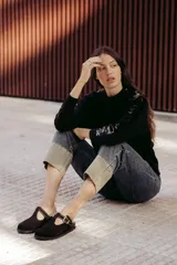 Zuecos marrones de cuero con hebilla dorada ajustable.