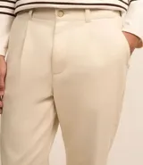 Pantalón de vestir color blanco, confeccionado en algodón con textura cuadriculada. Cuenta con cintura con trabillas, cierre tradicional y bolsillos laterales.