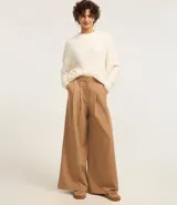 Suéter marrón de punto con cuello redondo y mangas largas ajustadas. Diseño slim alargado con efecto de pelitos.