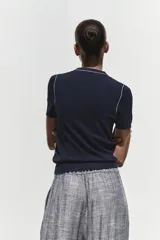 Top de punto color crema, de cuello redondo y manga corta con detalle de vivos a contraste en cuello y hombros.