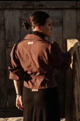 Camisa marrón con lunares blancos, corte clásico, cuello camisero, mangas 3/4 abullonadas y lazo ajustable en la cintura.