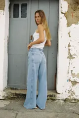 Pantalón de jean celeste de tiro medio y corte wide leg, con cinco bolsillos y costuras laterales marcadas.