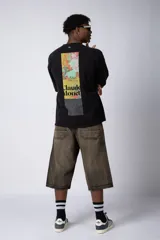 Remera negra de corte oversize con estampado en el pecho que reinterpreta la obra de Claude Monet.