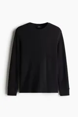 Remera negra de manga larga en punto waffle de mezcla de algodón de peso medio. Modelo con cuello redondo y ribete acanalado en cuello y puños.
