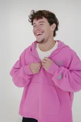 Canguro rosa con cierre parcial, capucha, bolsillo tipo canguro y logo estampado en el pecho y en la manga.