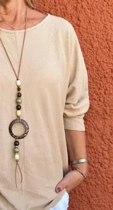 Buzo de manga larga color beige claro, con textura acanalada y corte holgado.