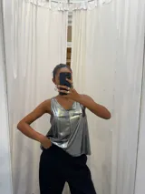 Musculosa gris de poliéster y rayón con spandex, escote en V y breteles anchos.