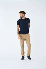 Pantalón chino de gabardina color beige, de corte regular, con cierre frontal y bolsillos laterales y traseros.