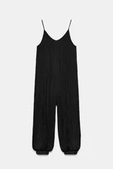 Mono negro de tejido satinado con efecto plisado vertical, escote en V y tirantes finos. El pantalón es de corte holgado con puños ajustados en los tobillos.