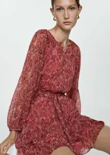 Vestido corto de manga larga con puños elásticos, estampado floral y lazo ajustable en la cintura.