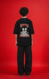 Remera negra de manga corta con cuello redondo y corte oversize. Estampado en la espalda con diseño de Mickey y Minnie Mouse disfrazados de diablos, con la frase "Hello Darling" en una pancarta.