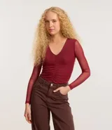 Body de tule color borgoña, con escote en V, mangas largas transparentes y fruncido delantero.